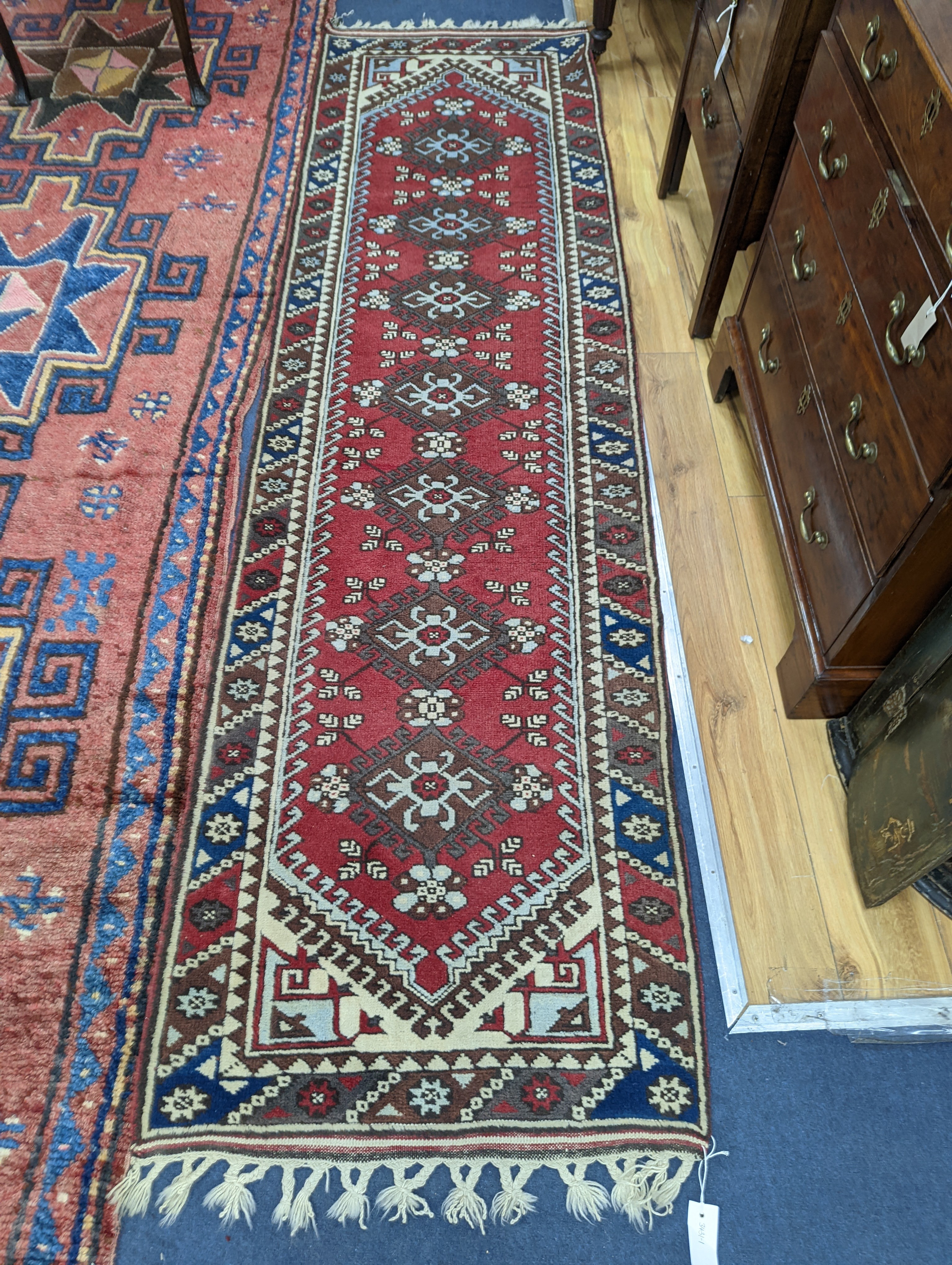 A Caucasian design red ground runner, 300 x 78cm